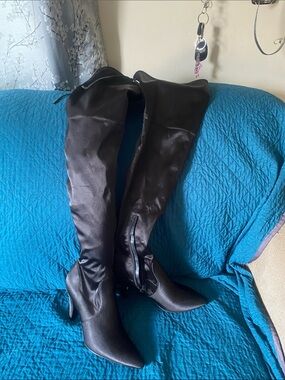 Guess These are black satin finish over the knee boots featuring a side zipper.